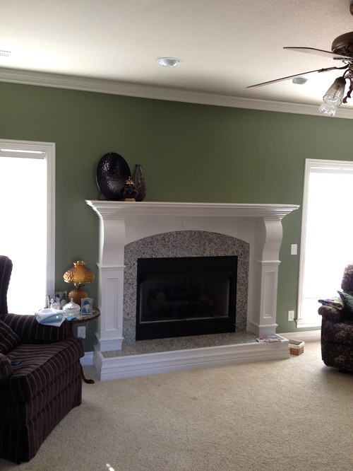 This is an example of a mid-sized traditional living room in Other with green walls, carpet, a standard fireplace and a tile fireplace surround.