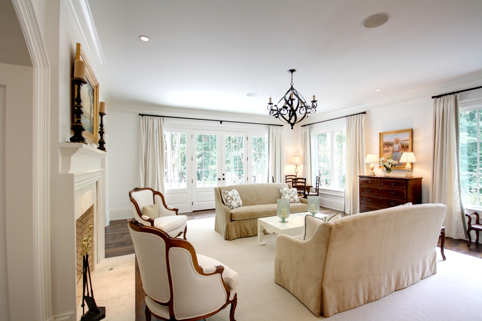 This is an example of a large traditional living room in Atlanta with white walls and a standard fireplace.