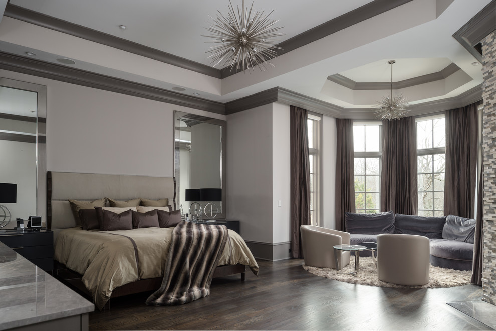 This is an example of a large contemporary master bedroom in Atlanta with grey walls, dark hardwood floors and a standard fireplace.