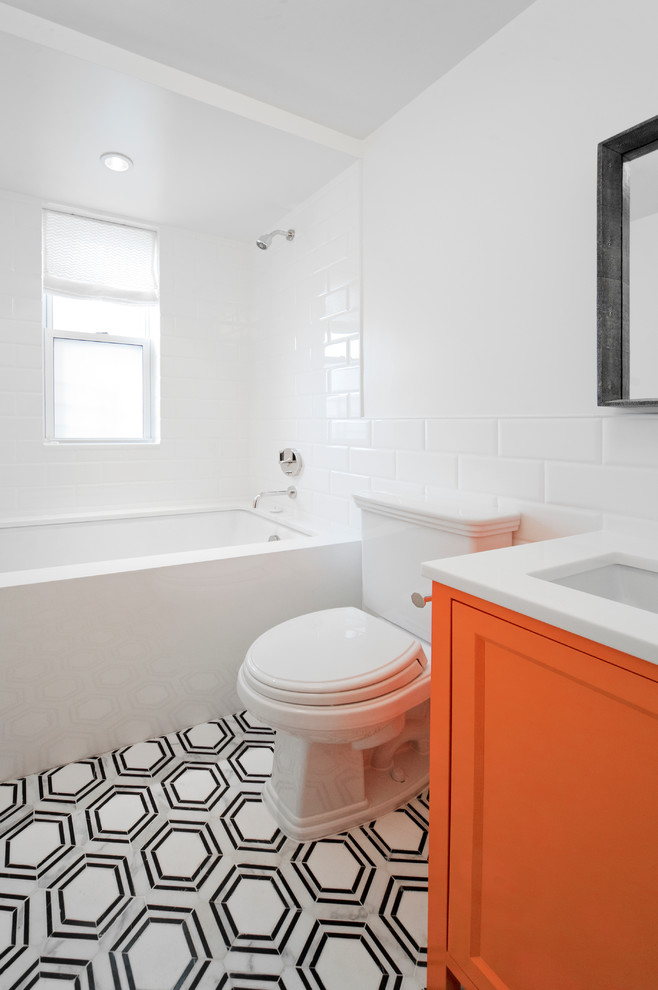 Photo of a small contemporary 3/4 bathroom in New York with recessed-panel cabinets, orange cabinets, an alcove tub, an alcove shower, a two-piece toilet, white tile, ceramic tile, white walls, marble floors, an undermount sink, quartzite benchtops, grey floor and a shower curtain.