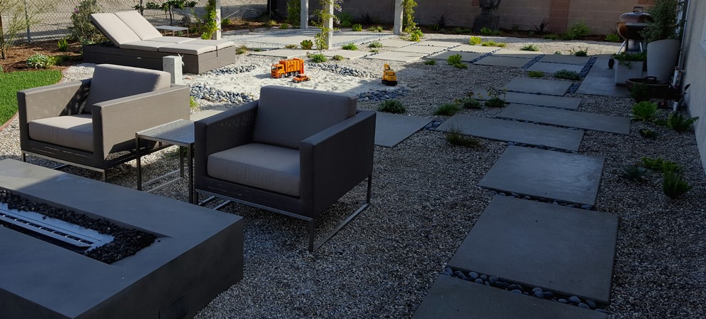 Photo of a mid-sized contemporary backyard garden in Orange County with a fire feature and gravel.