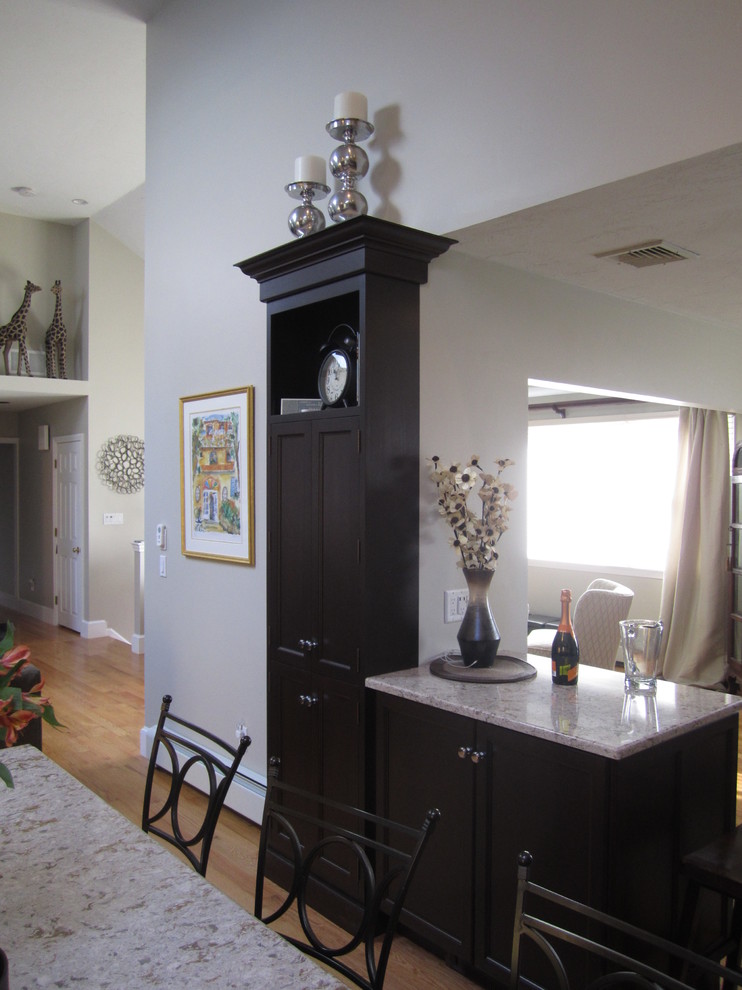 Eat-in kitchen - large transitional l-shaped light wood floor eat-in kitchen idea with shaker cabinets, black cabinets, marble countertops, white backsplash, subway tile backsplash, stainless steel appliances and an island