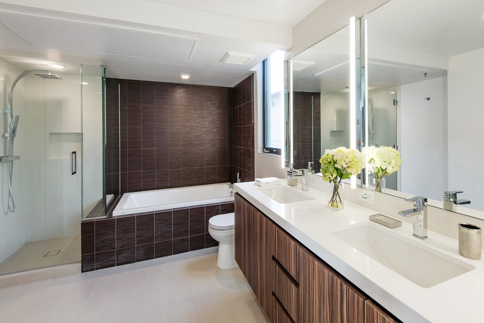 Large contemporary master bathroom in Los Angeles with white walls, flat-panel cabinets, medium wood cabinets, a drop-in tub, an alcove shower, a one-piece toilet, brown tile, porcelain tile, porcelain floors, an undermount sink, quartzite benchtops, beige floor and a hinged shower door.