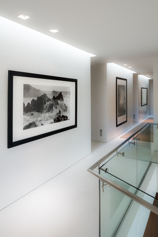 This is an example of a contemporary hallway in New York with white walls and white floor.