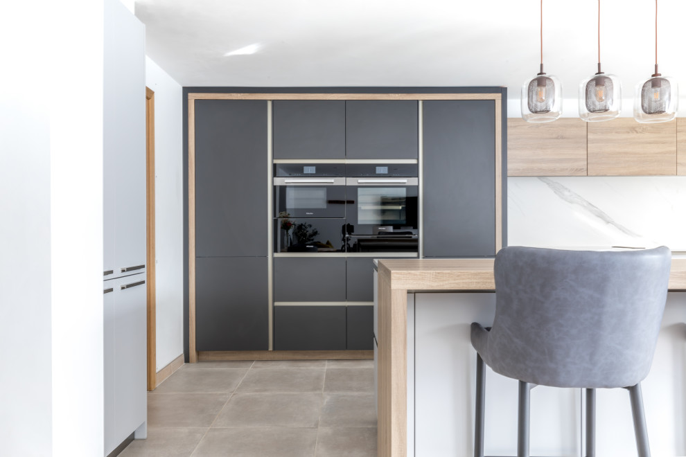 Diseño de cocinas en L contemporánea de tamaño medio abierta con armarios con paneles lisos, puertas de armario grises, encimera de acrílico, electrodomésticos de acero inoxidable, una isla y encimeras blancas