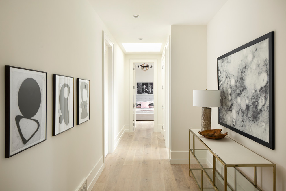 Transitional hallway in Calgary with white walls and light hardwood floors.