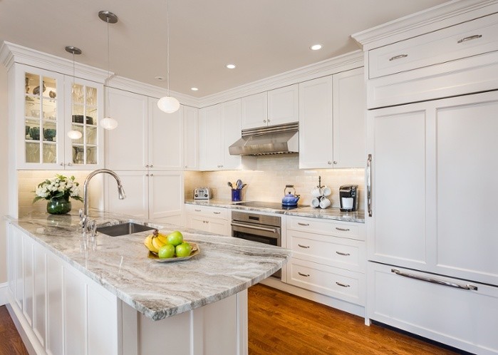 Inspiration for a transitional u-shaped medium tone wood floor eat-in kitchen remodel in Boston with an undermount sink, white cabinets and white appliances