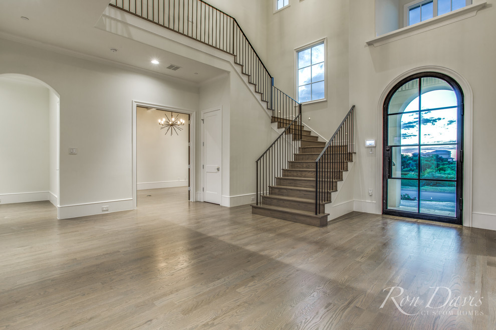 This is an example of a large mediterranean foyer in Dallas with medium hardwood floors, a single front door, a blue front door and brown floor.