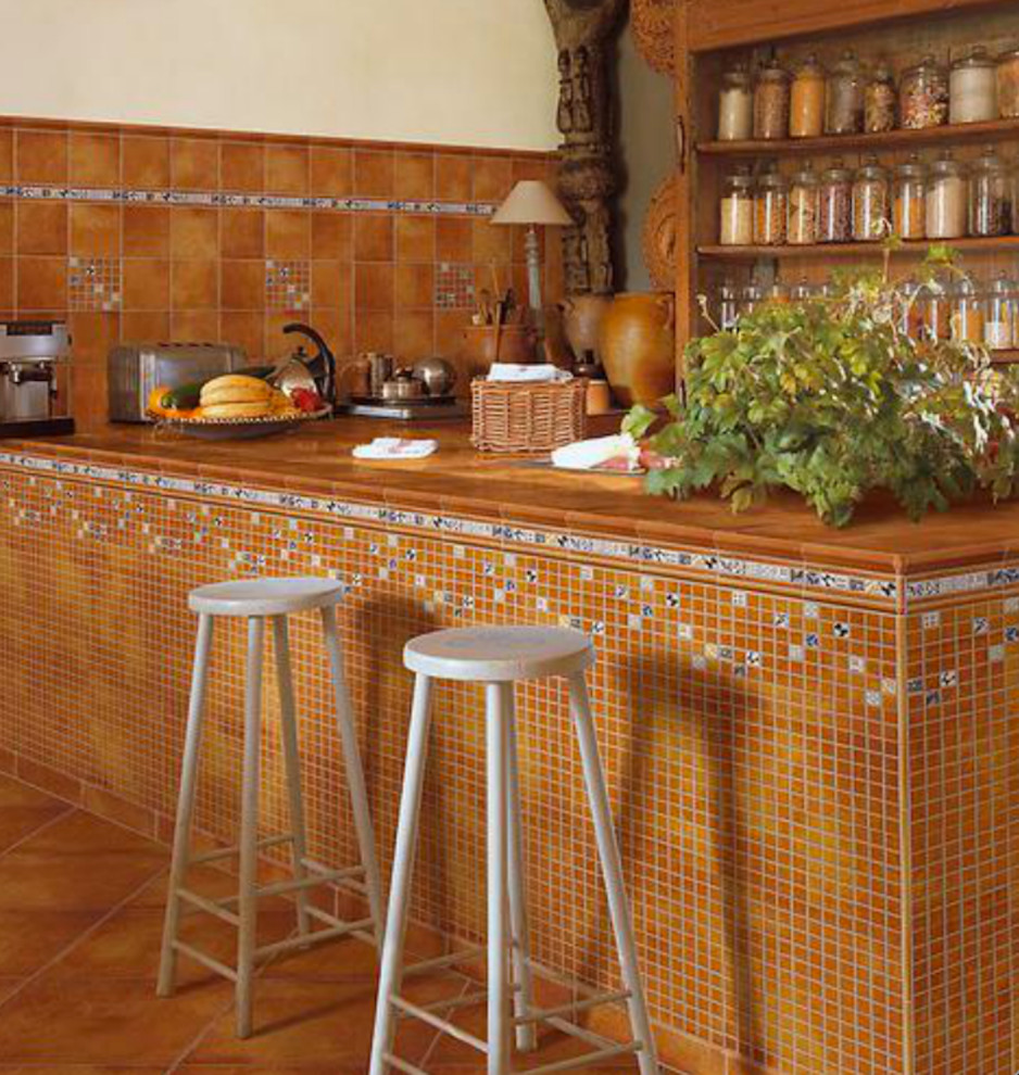 This is an example of a small mediterranean u-shaped separate kitchen in San Francisco with open cabinets, dark wood cabinets, tile benchtops, brown splashback, ceramic splashback, stainless steel appliances and terra-cotta floors.