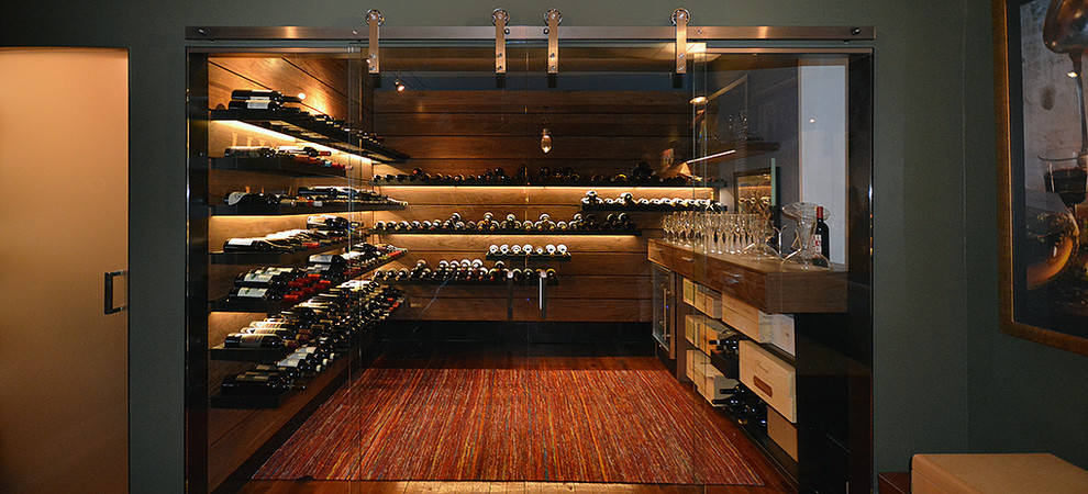 Design ideas for a mid-sized contemporary wine cellar in Kansas City with dark hardwood floors and display racks.