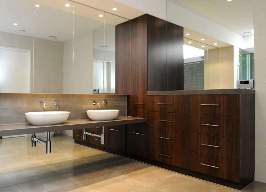 Large contemporary master bathroom in Melbourne with a vessel sink, flat-panel cabinets, medium wood cabinets, engineered quartz benchtops, a freestanding tub, an open shower, a one-piece toilet, beige tile, porcelain tile, beige walls and porcelain floors.