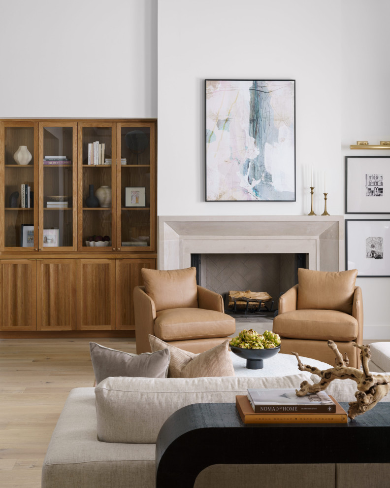 Example of a transitional light wood floor and beige floor living room design in Austin with white walls and a standard fireplace