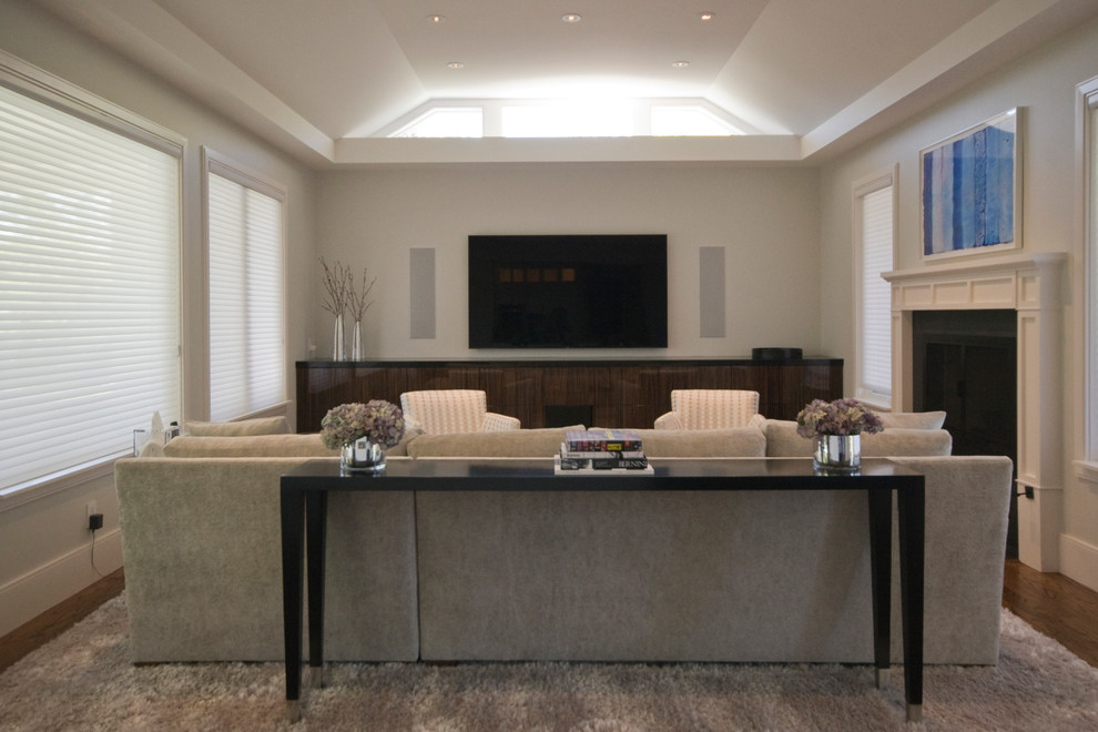 Photo of a mid-sized transitional enclosed home theatre in San Francisco with grey walls, dark hardwood floors and a wall-mounted tv.