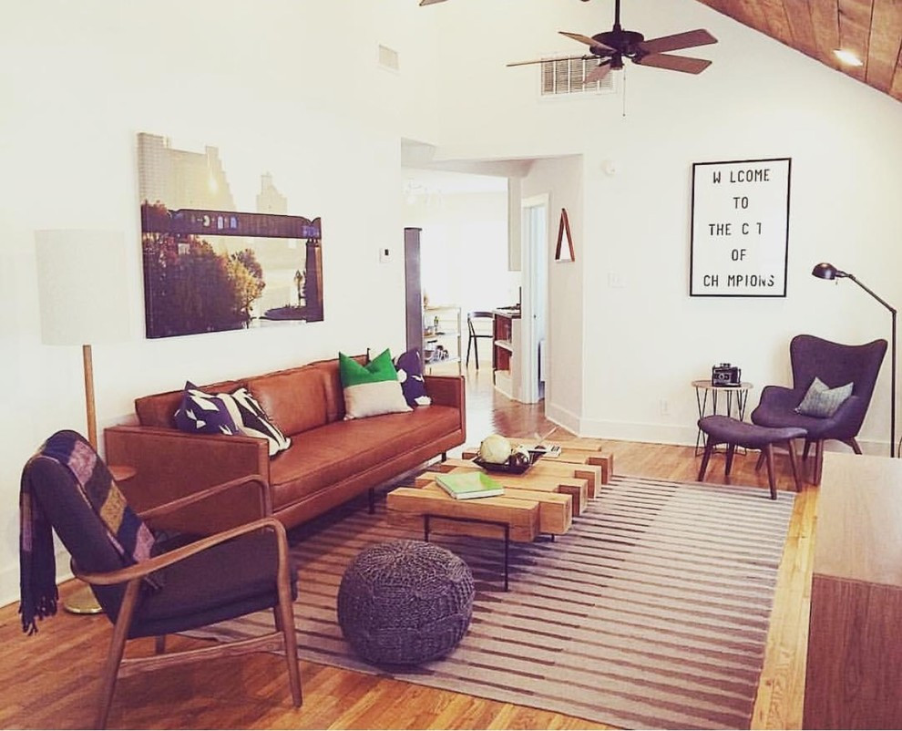 Photo of a mid-sized midcentury formal enclosed living room in Austin with white walls, medium hardwood floors, no fireplace and no tv.