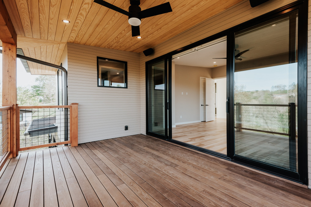 Deck - mid-sized transitional second story mixed material railing deck idea with a roof extension