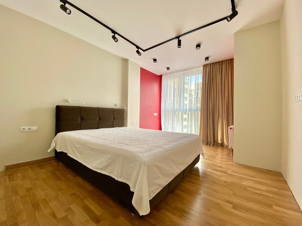 Источник вдохновения для домашнего уюта: гостевая спальня среднего размера, (комната для гостей) в современном стиле с зелеными стенами, полом из ламината, коричневым полом, обоями на стенах и акцентной стеной без камина