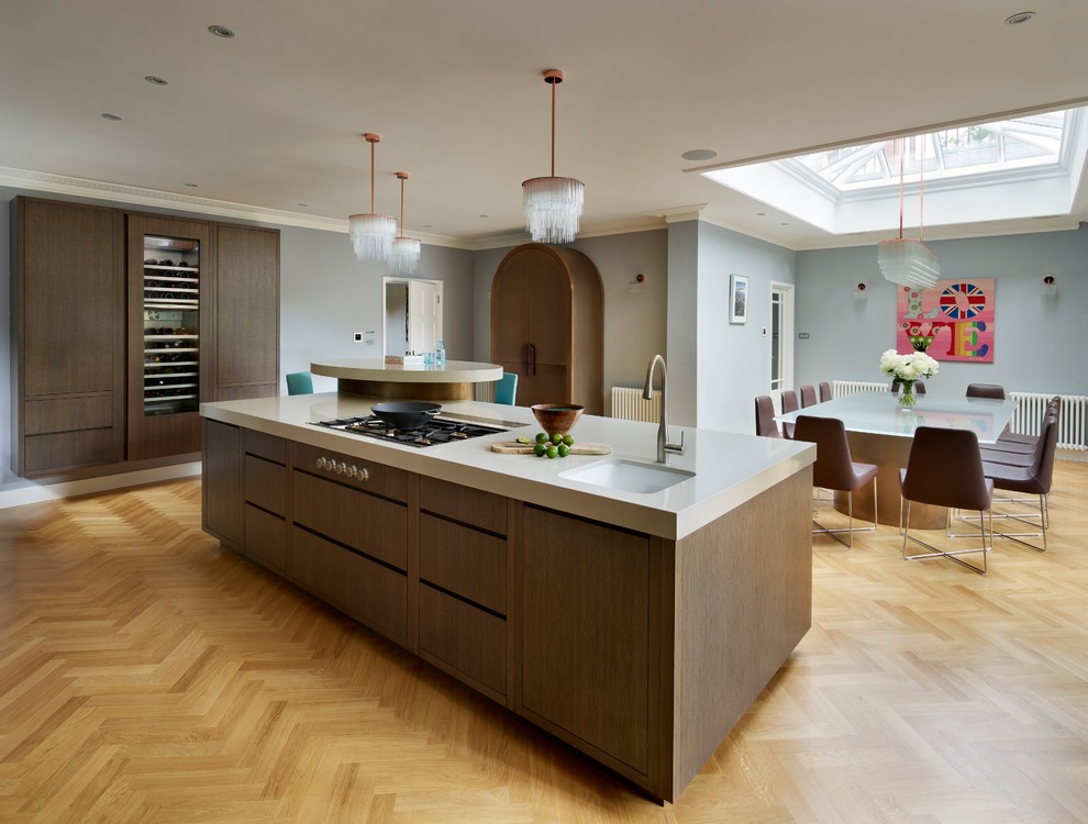 Contemporary eat-in kitchen in London with an integrated sink, flat-panel cabinets, dark wood cabinets, granite benchtops, panelled appliances, medium hardwood floors and with island.
