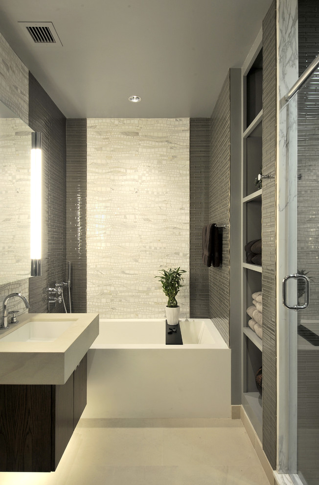 Modern master bathroom in New York with an integrated sink, flat-panel cabinets, dark wood cabinets, an alcove tub, an alcove shower, grey walls, gray tile and white tile.