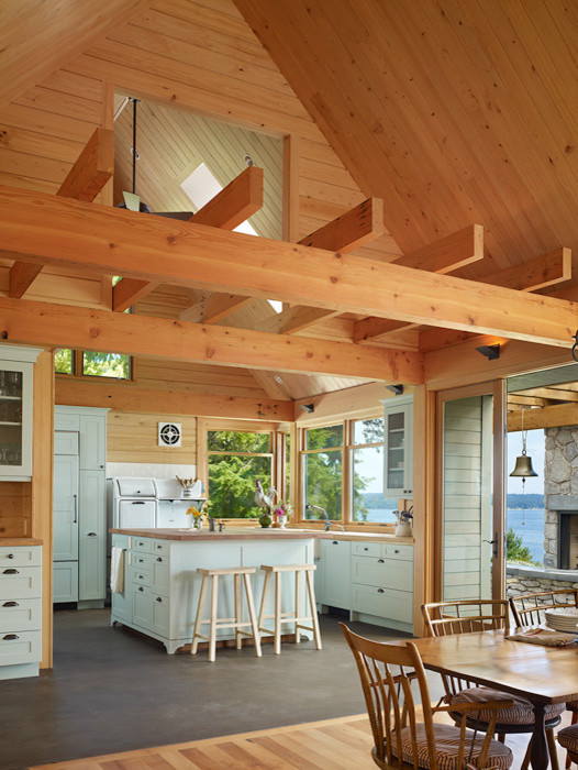 Photo of a mid-sized country kitchen in Seattle with wood benchtops, concrete floors and with island.