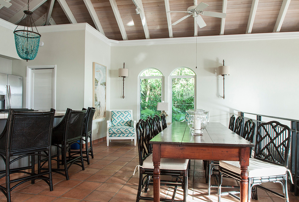 This is an example of a tropical open plan dining in Other with white walls, terra-cotta floors, vaulted and orange floor.