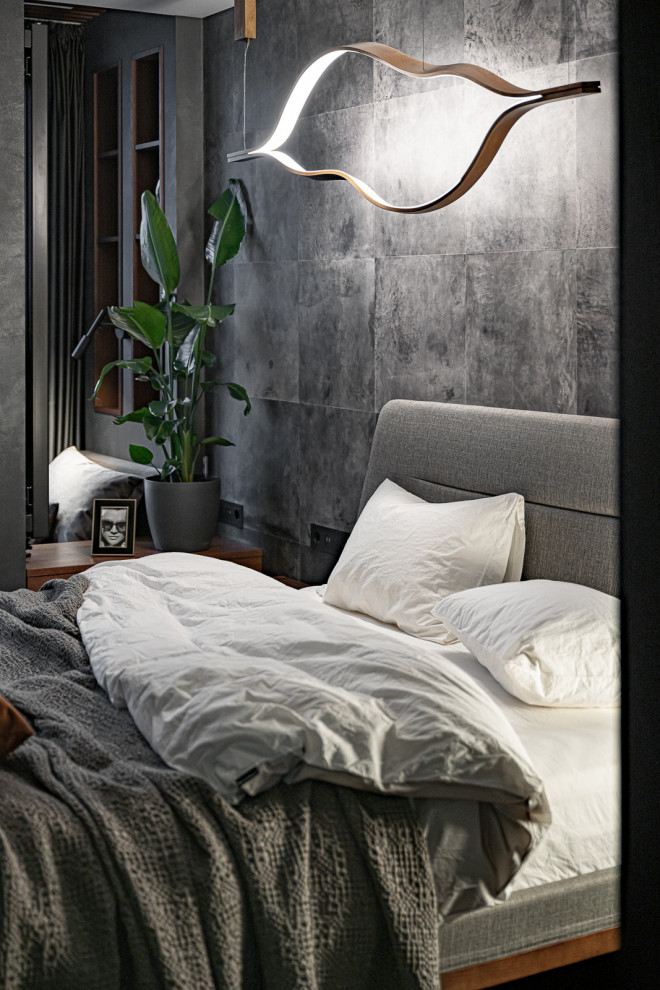 На фото: хозяйская, серо-белая спальня: освещение в современном стиле с серыми стенами, темным паркетным полом и красным полом