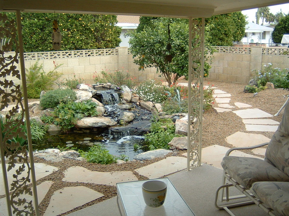Photo of a mid-sized backyard partial sun garden in Phoenix with with pond.