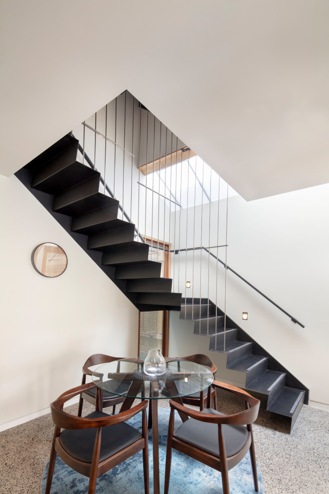 Photo of a large contemporary metal l-shaped staircase in Melbourne with metal risers and cable railing.