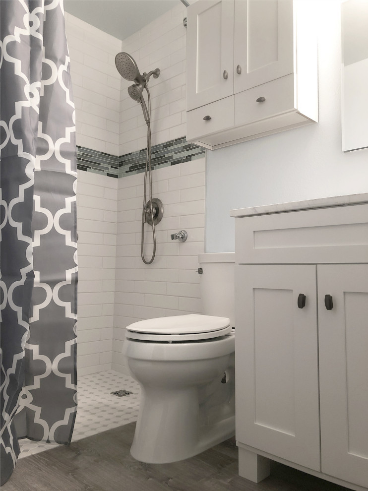 Inspiration for a small contemporary master bathroom in Seattle with recessed-panel cabinets, white cabinets, a curbless shower, a bidet, white tile, subway tile, white walls, vinyl floors, an integrated sink, marble benchtops, grey floor, a shower curtain, white benchtops, a niche, a single vanity and a freestanding vanity.