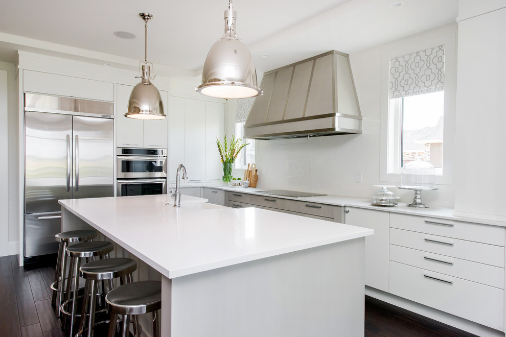 Example of a large transitional l-shaped dark wood floor eat-in kitchen design in Calgary with a farmhouse sink, flat-panel cabinets, quartz countertops, white backsplash, subway tile backsplash, stainless steel appliances and an island