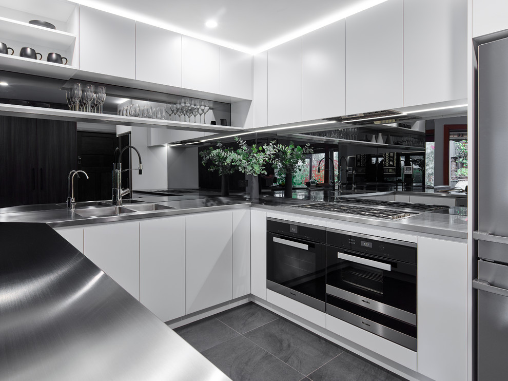 Inspiration for a large contemporary u-shaped eat-in kitchen in Other with an integrated sink, white cabinets, stainless steel benchtops, glass sheet splashback, stainless steel appliances, ceramic floors and a peninsula.