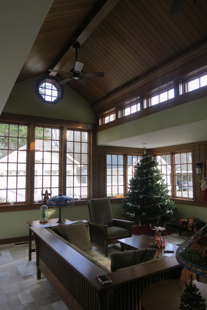 This is an example of a mid-sized arts and crafts sunroom in Cleveland with travertine floors, a standard fireplace, a stone fireplace surround and a standard ceiling.