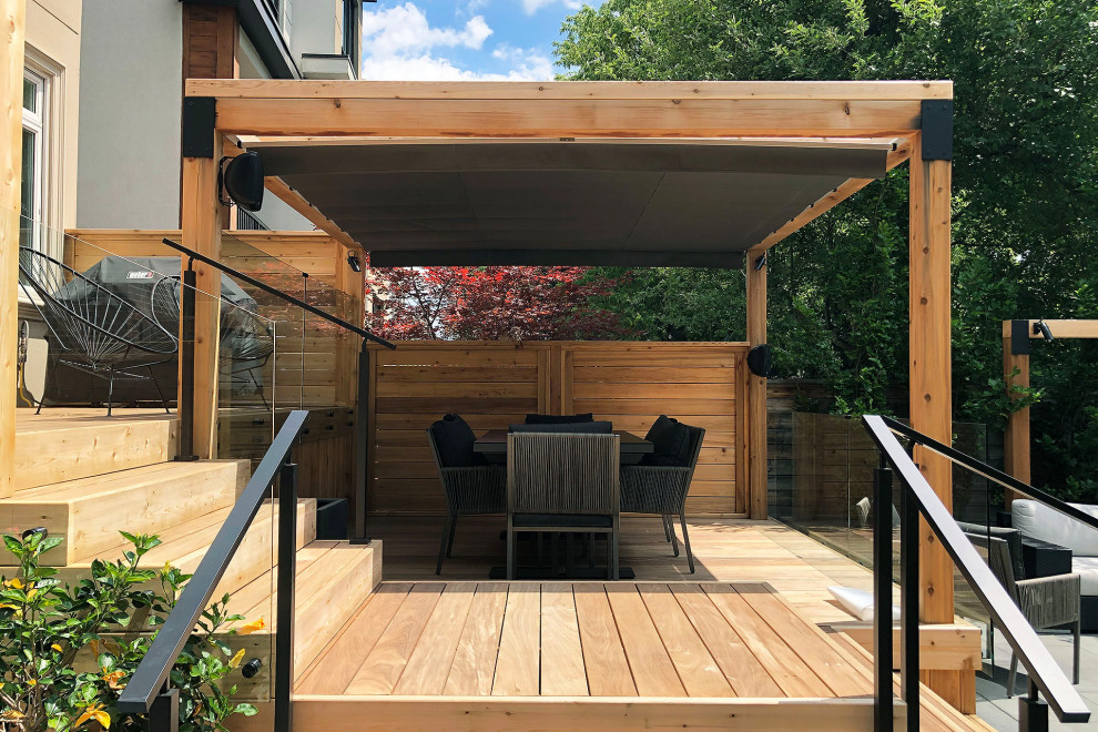 Ejemplo de terraza minimalista en patio trasero con pérgola y barandilla de madera