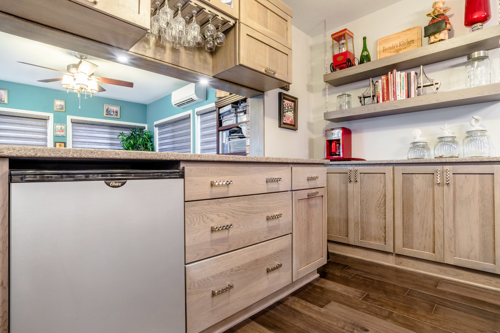 Inspiration for a mid-sized transitional u-shaped medium tone wood floor enclosed kitchen remodel in Miami with a farmhouse sink, shaker cabinets, gray cabinets, quartz countertops, gray backsplash, glass tile backsplash, white appliances and an island