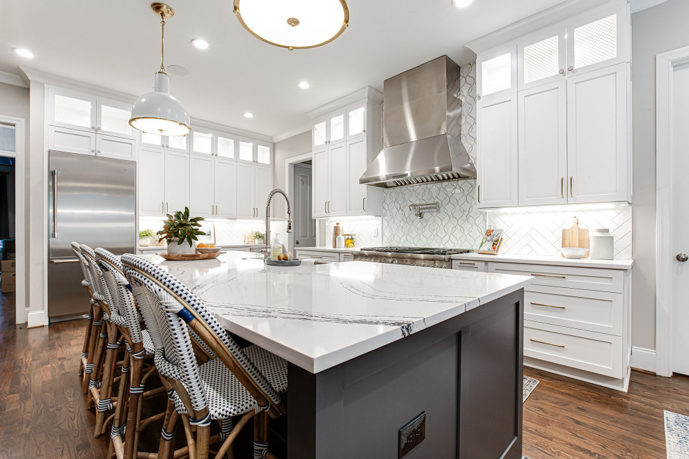 Open concept kitchen - large transitional l-shaped dark wood floor open concept kitchen idea in Atlanta with shaker cabinets, white cabinets, quartz countertops, white backsplash, subway tile backsplash, stainless steel appliances, an island and white countertops