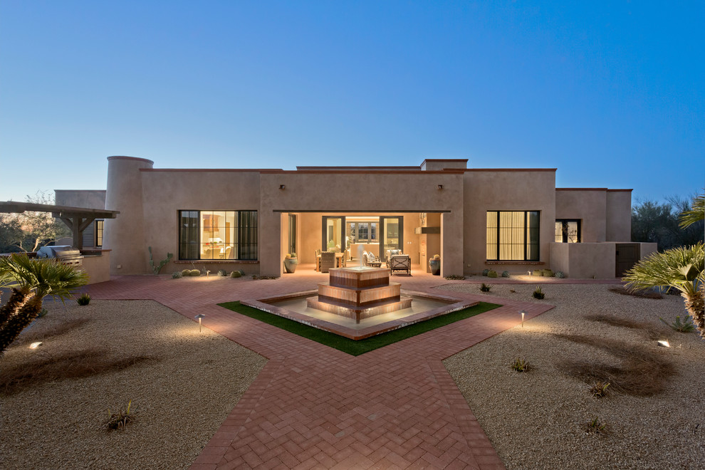 This is an example of a mediterranean stucco exterior in Phoenix with a flat roof.