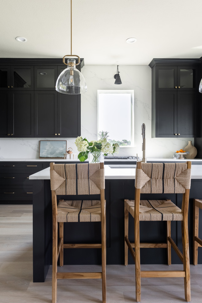 Inspiration for a large transitional l-shaped eat-in kitchen in Dallas with a single-bowl sink, shaker cabinets, black cabinets, quartz benchtops, white splashback, engineered quartz splashback, black appliances, vinyl floors, with island, beige floor and white benchtop.