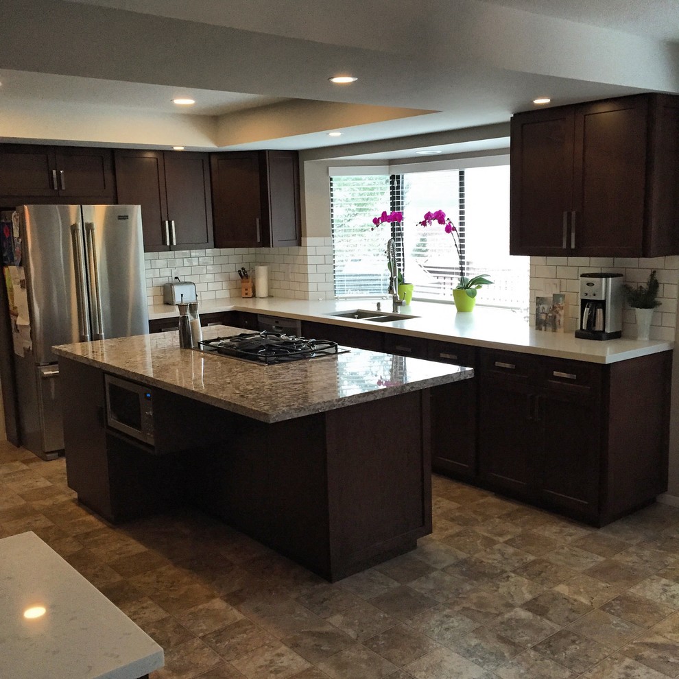 Large modern u-shaped kitchen in Vancouver with dark wood cabinets, quartz benchtops and with island.