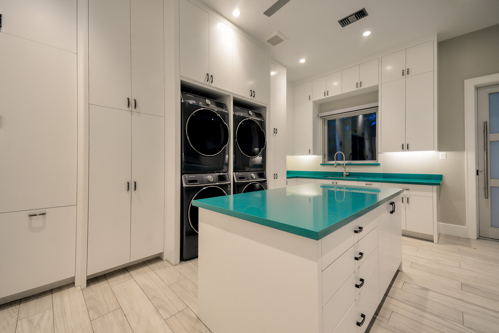 Large contemporary u-shaped utility room in Houston with an undermount sink, flat-panel cabinets, white cabinets, quartz benchtops, grey walls, porcelain floors and a stacked washer and dryer.