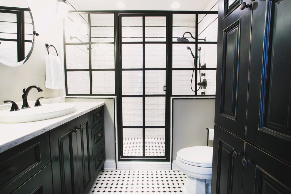 Design ideas for a mid-sized industrial master wet room bathroom in Other with recessed-panel cabinets, black cabinets, a two-piece toilet, marble, grey walls, laminate floors, a drop-in sink, multi-coloured floor and a hinged shower door.