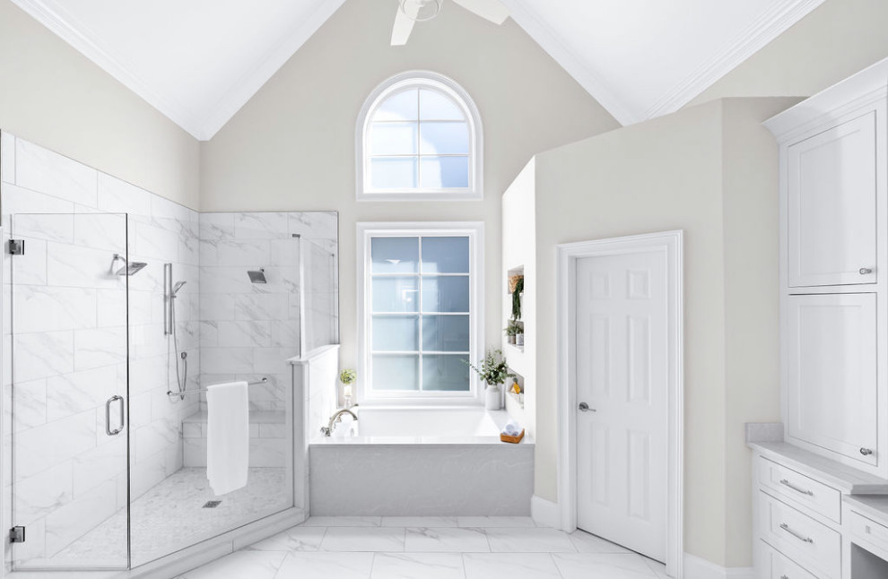 Идея дизайна: главная ванная комната среднего размера в стиле неоклассика (современная классика) с фасадами в стиле шейкер, белыми фасадами, полновстраиваемой ванной, душем без бортиков, унитазом-моноблоком, белой плиткой, керамогранитной плиткой, серыми стенами, полом из керамогранита, врезной раковиной, столешницей из кварцита, белым полом, душем с распашными дверями, белой столешницей, нишей, тумбой под одну раковину, встроенной тумбой и сводчатым потолком