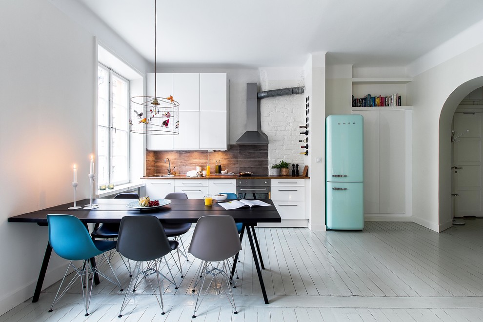 Large scandinavian single-wall eat-in kitchen in Stockholm with flat-panel cabinets, white cabinets, wood benchtops, coloured appliances, painted wood floors, no island and a drop-in sink.