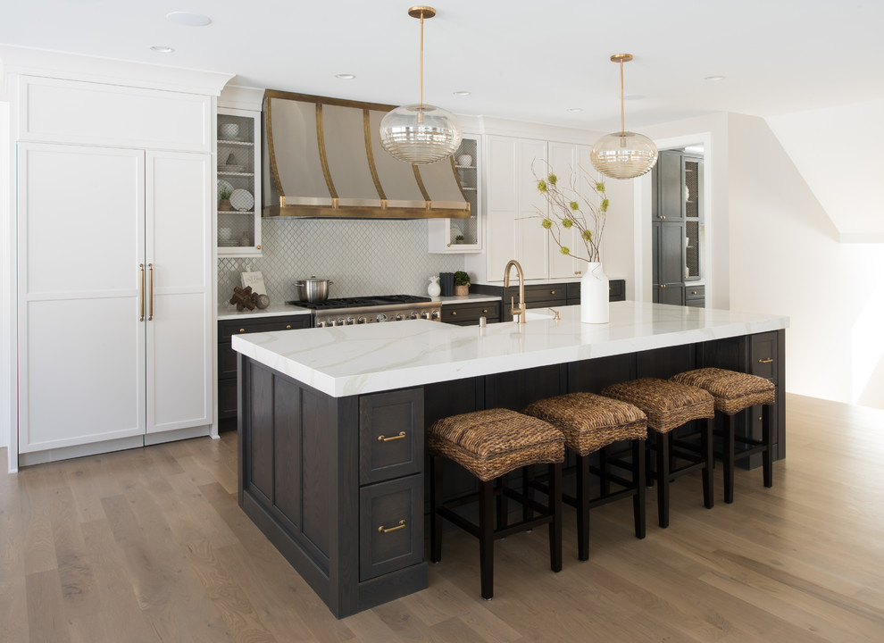 Open concept kitchen - mid-sized transitional galley light wood floor and beige floor open concept kitchen idea in Minneapolis with a farmhouse sink, quartz countertops, stainless steel appliances, an island, recessed-panel cabinets, gray cabinets, gray backsplash and ceramic backsplash