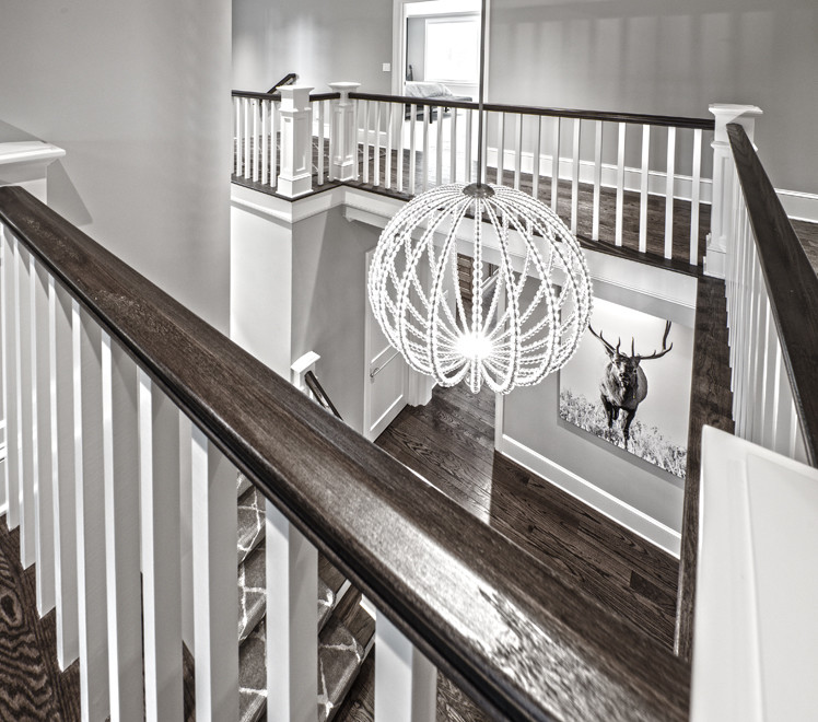 This is an example of a mid-sized transitional wood u-shaped staircase in Seattle with painted wood risers and wood railing.