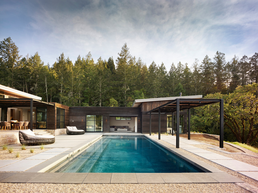 Ejemplo de piscina infinita contemporánea extra grande rectangular en patio trasero con privacidad