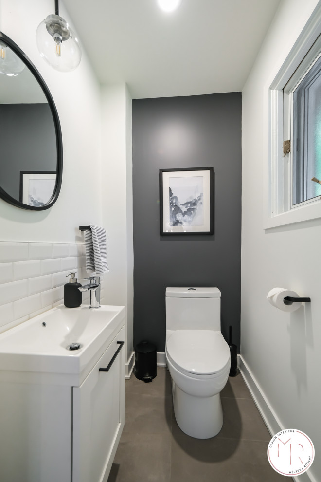 Cette image montre un petit WC et toilettes nordique avec un placard à porte shaker, des portes de placard blanches, WC à poser, un carrelage blanc, des carreaux de céramique, un mur blanc, un sol en carrelage de céramique, un lavabo intégré, un sol gris et meuble-lavabo suspendu.