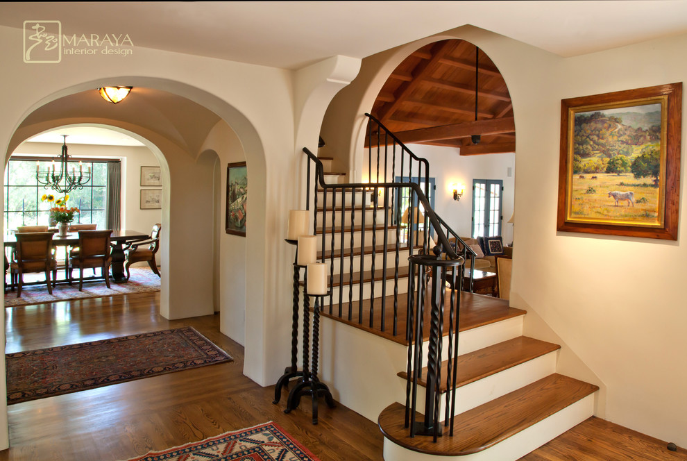 Photo of a mid-sized mediterranean foyer in Santa Barbara with white walls, medium hardwood floors, a single front door and a dark wood front door.