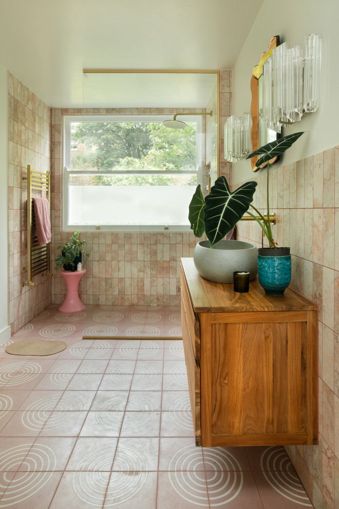 Idéer för ett mellanstort modernt badrum för barn, med släta luckor, skåp i mellenmörkt trä, en öppen dusch, en vägghängd toalettstol, rosa kakel, marmorkakel, rosa väggar, cementgolv, träbänkskiva, rosa golv och med dusch som är öppen