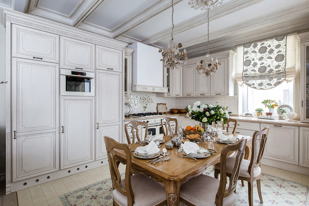 This is an example of a traditional l-shaped eat-in kitchen in Moscow with grey cabinets, beige splashback, beige floor, white appliances and no island.