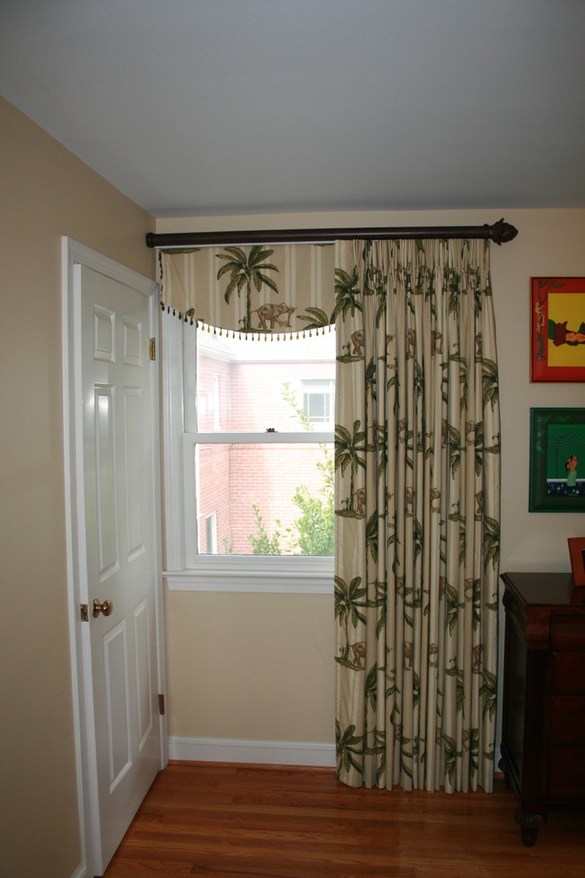 This is an example of a tropical master bedroom in DC Metro with beige walls.