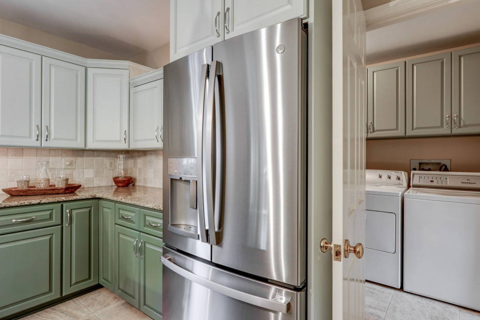 Mid-sized transitional l-shaped ceramic tile and beige floor eat-in kitchen photo with a double-bowl sink, raised-panel cabinets, green cabinets, granite countertops, beige backsplash, ceramic backsplash, stainless steel appliances, an island and beige countertops